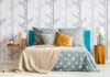 Bed against forest motif wallpaper